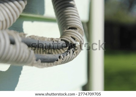 Weathered and broken electrical wire insulation outdoors