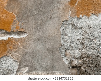 Weathered damaged wall texture background. Peeling orange stucco and cracked grey cement. Distressed raw concrete building facade backdrop.