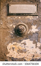 Weathered Door Bell And Blank Name Label On Damaged Wall Background