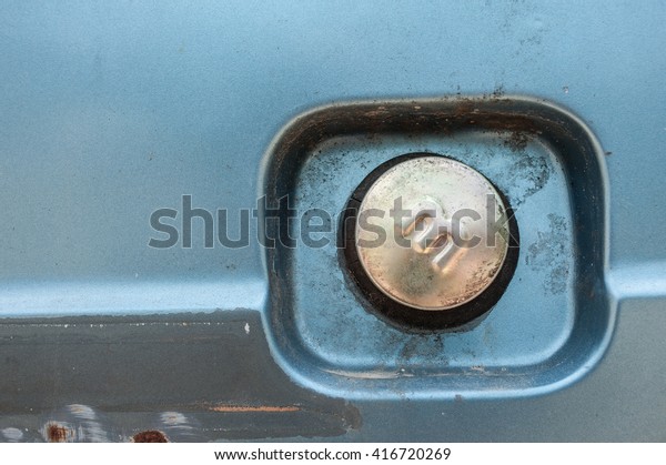 Weathered fuel cap of an\
old blue truck