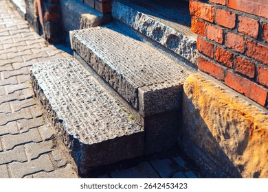 Weathered granite steps, showcasing the intricate patterns and textures of the brick wall. Stone steps, showing the transition from pavement to building