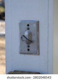 Weathered gray outdoor toggle light switch in the OFF position, mounted on a white painted wooden post, symbolizing power control and outdated technology.