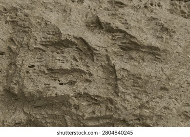 weathered grey stone surface. The texture features deep crevices, pits, and rugged natural