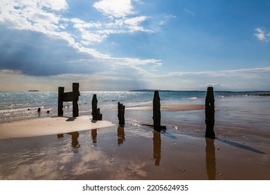 A weathered groyne at Camber Sands in East Sussex, with refelctions in the receding tide