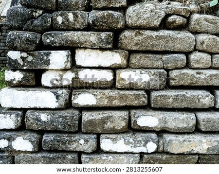 Weathered heritage bricks form an old masonry wall in Indonesia, photographed in daylight to show texture, age, decay, and traditional construction.