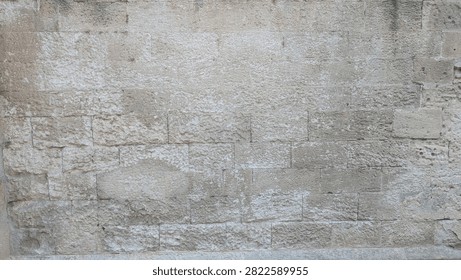 Weathered limestone ashlar wall texture in warm natural light