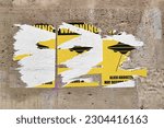 Weathered limestone wall with three torn yellow and black posters in the middle an UFO abducting a man sign with the message "Warning - Alien abductions may occurs in this area" written around.