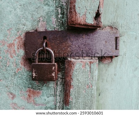 Weathered Lock Secured on Rusty Bolt of Aged Wooden Door