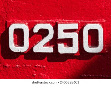 Weathered numbers zero, two, five, 0250, or 0, 2, 5 painted white on a piece of red metal. Abstarct numeral background for design.