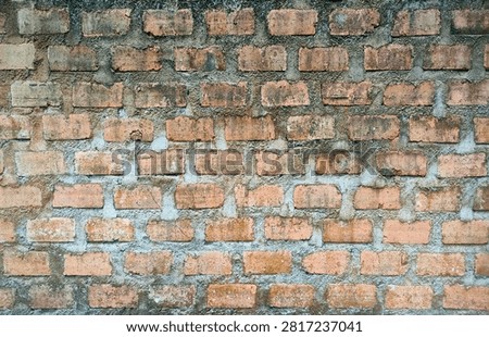 Weathered old bricks wall with cement mortal joints background