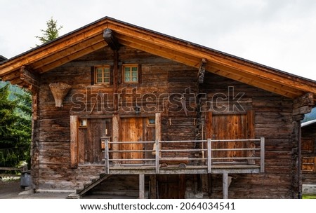 Weathered old wood texture background. Facade wooden house in village in Swiss Alps. The barns, stores, stables and old houses. Timber wood wall texture background.