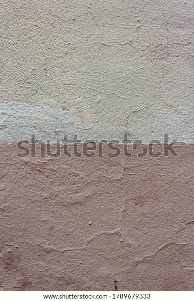 Weathered and peeling building exterior stucco wall\
painted white and salmon pink. Wall Painted Two Tone. The wall is\
divided into borders of different colors. Abstract geometric\
pattern on the wall.