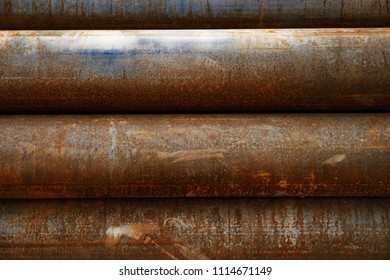 Weathered pipe surface showcasing intricate rusted patina and grime layers, emphasizing textural craftsmanship in metallic tubing. Close-up of abundant rust and grime creating earthy ornamentation with aged grainy plating. This industrial depiction highlights ornamental grime blending with recycled styling, producing ambient pipeline artwork with gritty artistic tracery. Visual aesthetic displays worn, painted, and brushed textures enhancing factory-style pipeline imagery in a studio shot.