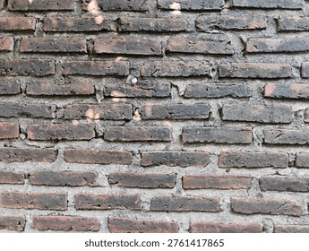 ​Old weathered red brick wall texture background with rough cement joints and vintage rustic feel.