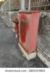 Weathered Red Fire Hydrant Box and Pillar on Concrete Roadside