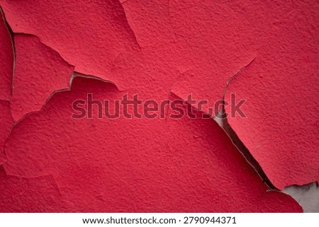 Weathered red painted wall featuring natural cracks and distressed texture, perfect for creative backgrounds and graphic design