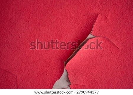 Weathered red painted wall featuring natural cracks and distressed texture, perfect for creative backgrounds and graphic design