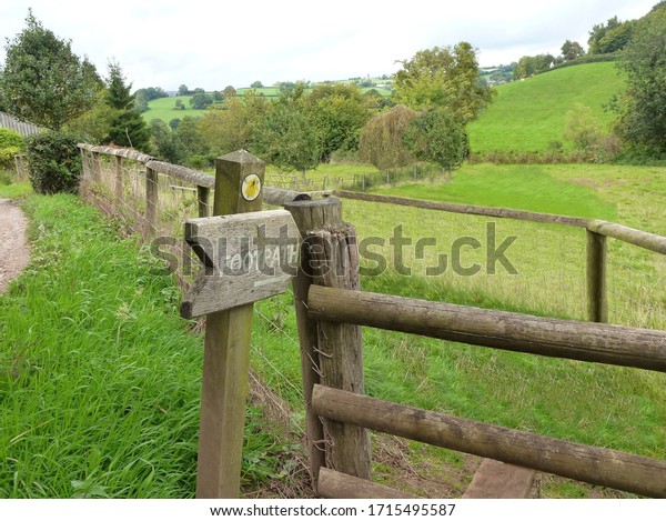 Weathered rustic footpath\
sign and stile.