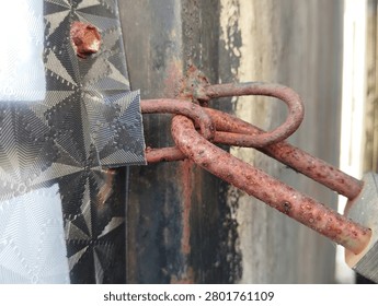 Weathered rusty padlock and corroded chain securing a metal gate, showcasing aging, security, decay, and industrial character. Ideal for protection, access, and vintage concepts.