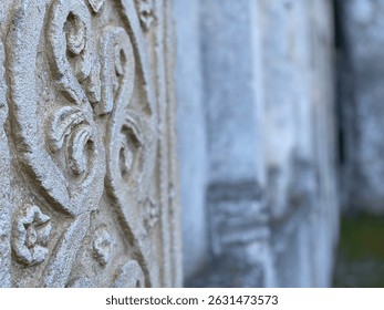 Weathered stone pillar featuring intricate medieval carvings representing architectural heritage of Serramonacesca, Abruzzo region