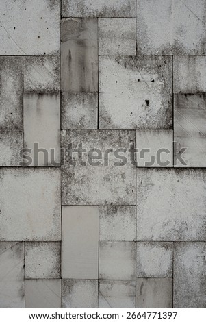 A weathered stone tile wall with a random rectangular pattern. This grunge, abstract texture makes for a perfect urban or industrial background.