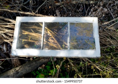 Weathered Three Pane Window On Top Of Yard Waste Pile.