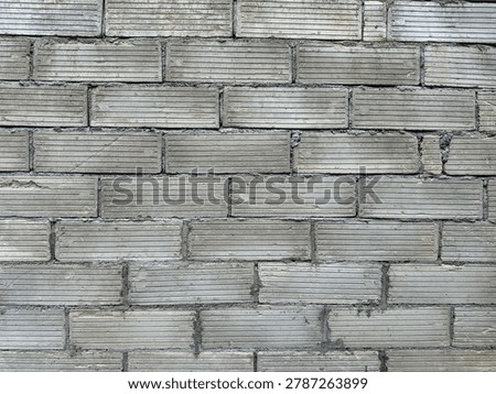 Weathered utilitarian grey blockwork showcasing intricate linear patterns on a durable structural