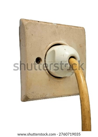 Weathered vintage electrical wall socket with power plug and thick hanging cable isolated on white background side view macro shot for home renovation construction and maintenance concept projects.