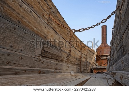 Weathered wood and iron chain on ore wagon and metal smokestack on Old Dinah steam tractor, antique mining equipment, Furnace Creek, Death Valley National Park, California
