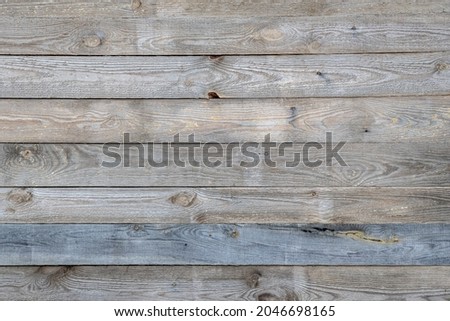 Weathered wooden siding background. Teture of a barn wall covered by wood planks