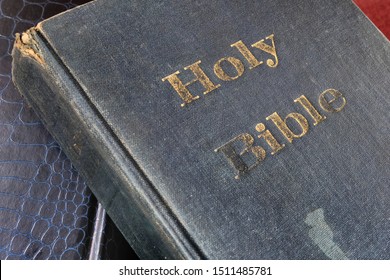 Weathering through times - front hardcover of a weathered, old and faded Holy Bible where many faithful Christians read the scripture for guidance, hope, inspiration and salvation. - Shutterstock ID 1511485781
