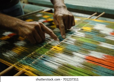 weaving and manufacturing of handmade carpets closeup. man's hands behind a loom - Powered by Shutterstock