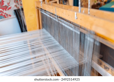 Weaving, traditional crafts,Close-up of a loom weaving, Woven silk,using cotton and silk string stretch and woven by using mechanic wooden machine to weave - Powered by Shutterstock