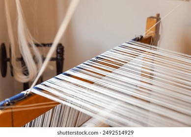 Weaving, traditional crafts,Close-up of a loom weaving, Woven silk,using cotton and silk string stretch and woven by using mechanic wooden machine to weave - Powered by Shutterstock