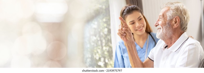 Web banner Man being cared for by a private Asian nurse at home suffering from Alzheimer's disease to closely care for elderly patients with copy space on left - Shutterstock ID 2193975797