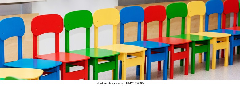 Web Banner From Row Of Empty Multi Colored Kids Chairs. Kindergarten Interior Details, Living Room No People. Cancellation Of Events, Bans On Celebrations.  Homeschooling, Staying At Home, Pandemic.