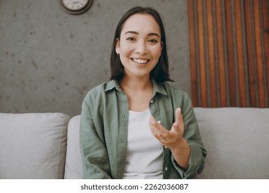 Web cam view head shot close up young woman wear casual clothes record get video call talk use pc laptop sits on grey sofa couch stay at home hotel flat rest relax spend free spare time in living room - Powered by Shutterstock