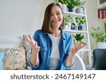 Web cam view of young attractive woman talking in home interior