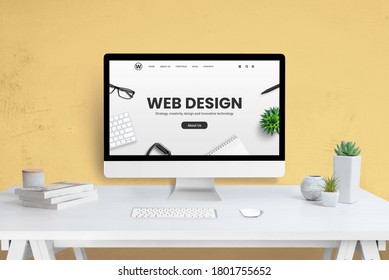 Web-Design-Firma Webseite auf Computer-Anzeige. Modernes, flaches Webseitendesign-Konzept. Arbeitstisch mit Pflanzen und Büchern. gelbe Wand auf Hintergrund