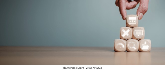 Web design and development concept, Hand holding wooden block on desk with web coding, design, coding, testing, web analytics and content management icon on virtual screen.