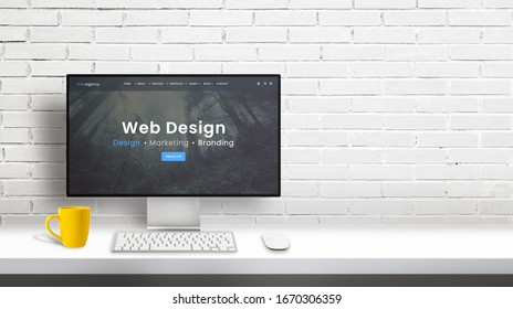 Web Design Studio Computer Display With Agency Portfolio Web Page. Copy Space Beside On White Brick Wall