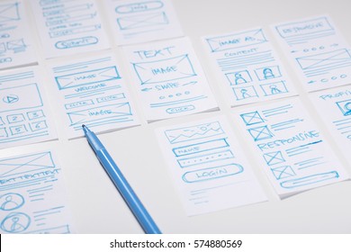 Web designer desk with sketches of screens for mobile application. Developing wireframe for mobile user experience