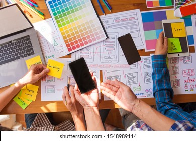 The Web Designer Team Is Helping To Design Applications For Mobile Phones. UX UI Designer Concept