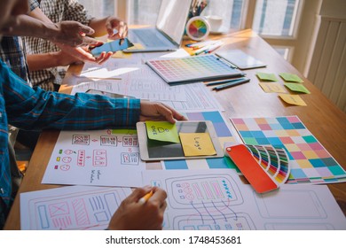 The web designer team is helping to design applications for mobile phones. UX UI designer concept - Shutterstock ID 1748453681