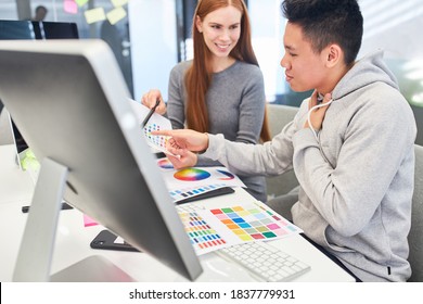 Web-Designer-Team auf dem Computer diskutiert Grafikdesign und Farbdesign
