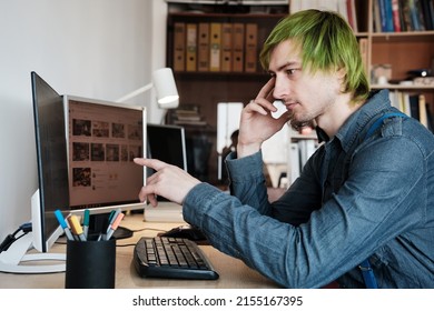 Web Designer Working On Computer In Office. Young Man With Green Hair.