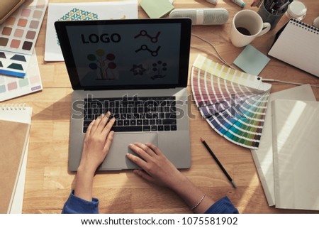 Web designer working on new logotype for a company, view from above