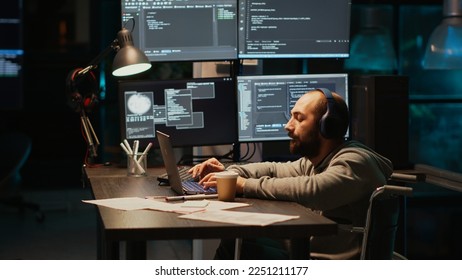 IT web developer writing source code in office, dealing with physical disability at night. Software engineer wheelchair user working late to develop new server database with html script.