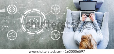 Web development concept with man using a laptop in a modern gray chair