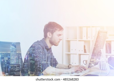 Web Master Working In His Big City Office At Large Computer. Cityscape At Foreground. Concept Of IT Work. Toned Image. Double Exposure